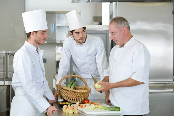 Profesor ayudando a los estudiantes a entrenar para trabajar en catering —  Fotos de Stock