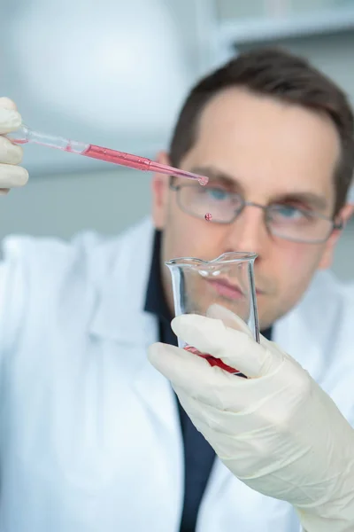科学者と研究室の背景に薬液をドロップ — ストック写真