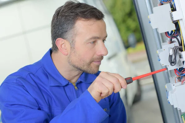 Tradesman repairing a distribution board — Stok fotoğraf