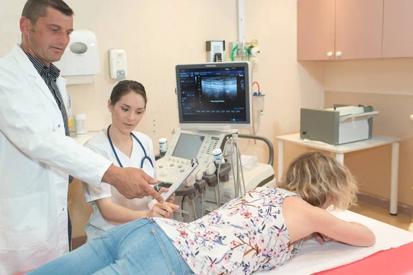 Läkare och sjuksköterska kontrollera på kvinnlig patient med ryggproblem — Stockfoto