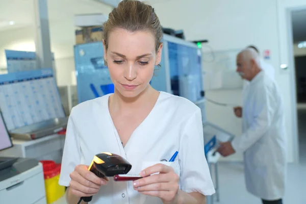 Enfermero verificando los niveles de stock en farmacia hospitalaria usando escáner — Foto de Stock