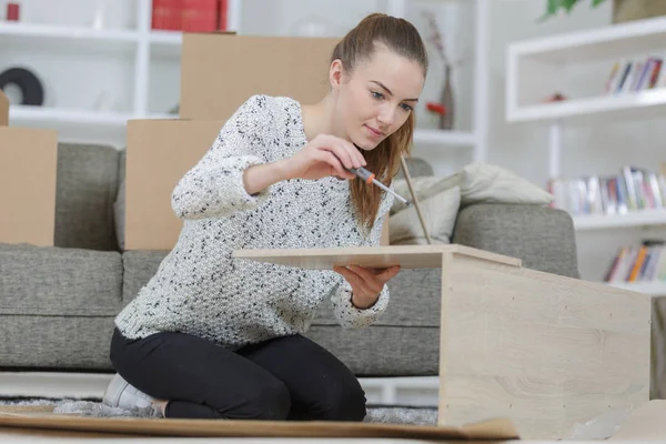 Kvinnan montering trämöbler — Stockfoto