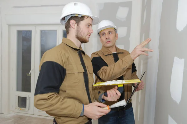 Byggnadsarbetare bära arbetare övergripande med mur puts verktyg — Stockfoto