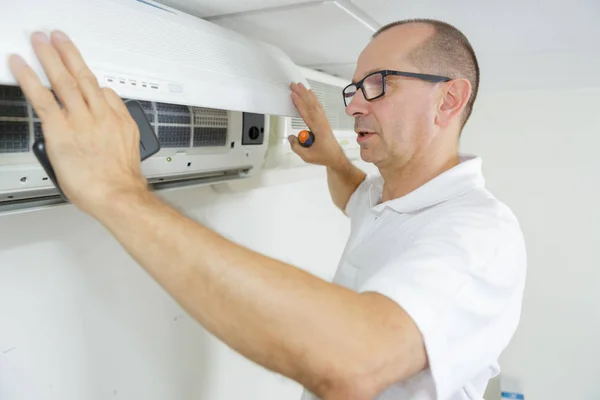 Volwassen mannelijke technicus reinigingssysteem airconditioning thuis — Stockfoto