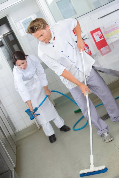 Restaurant medewerkers schoonmaak van de keukenvloer — Stockfoto