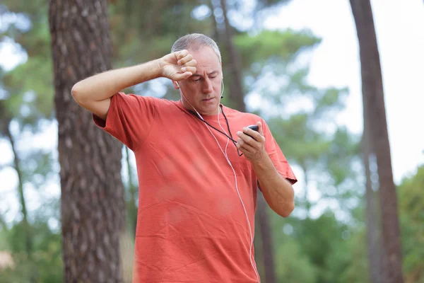Muž používající sportovní hodinky pro načasování spuštění cvičení — Stock fotografie