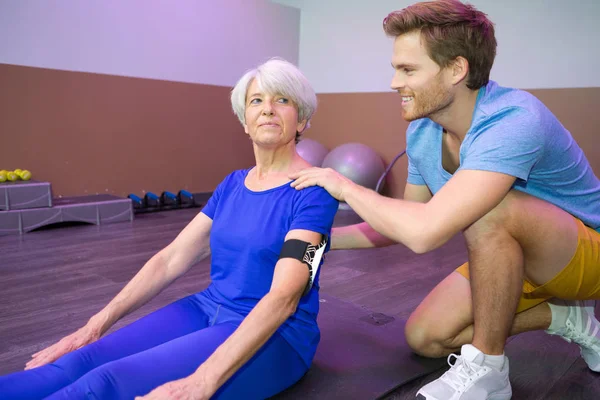 Positive ältere reife Frau mit männlichem Trainer — Stockfoto