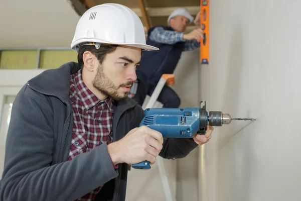 Travailleurs du chantier de construction forant avec une machine ou une perceuse — Photo