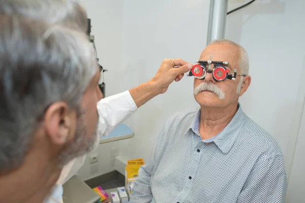 Médico examinando paciente idoso do sexo masculino — Fotografia de Stock