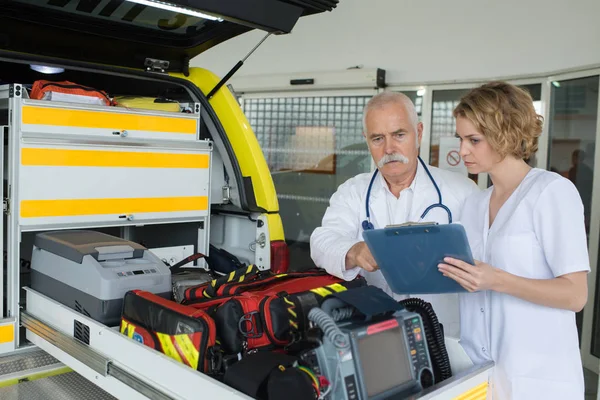 Paramédicos del equipo revisando equipo en una ambulancia —  Fotos de Stock