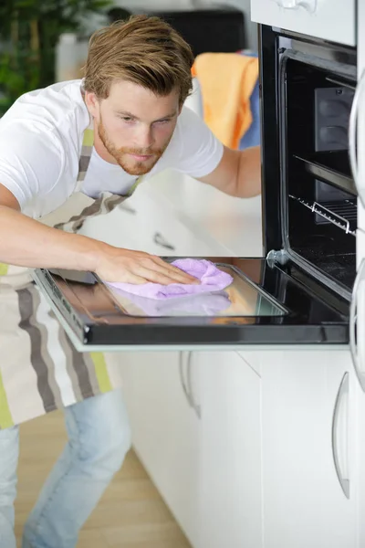 Uomo pulizia forno a casa — Foto Stock