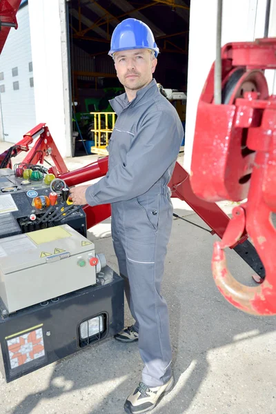 Worker operating a crane at a construction site — Stock Photo, Image