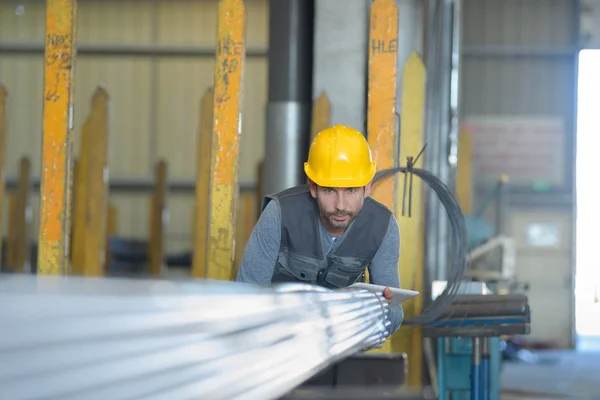 Travailleur déplacement barre d'acier stockage à l'intérieur de l'entrepôt — Photo