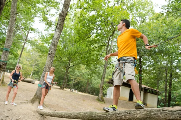 Man en vrienden bij de extreme touwbaanparcours — Stockfoto