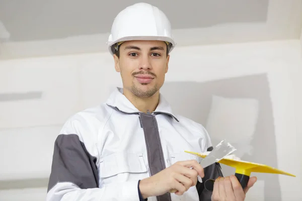 Construtor com espátula com gesso na mão — Fotografia de Stock