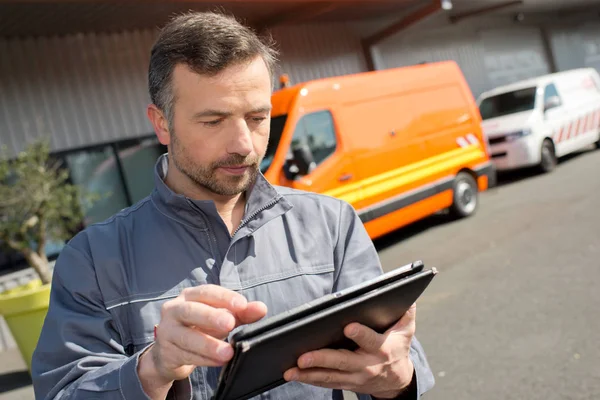 Worker writing on clipping board outside — Stock Photo, Image