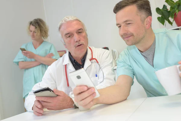 Doctors with mobile phone in hands in office — Stock Photo, Image