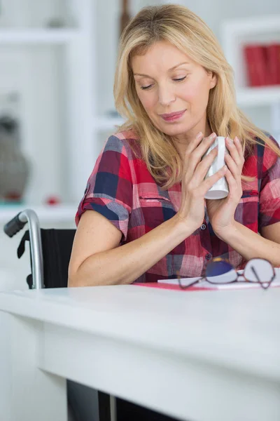 Deprimerad kvinna som sitter i rullstol hemma — Stockfoto