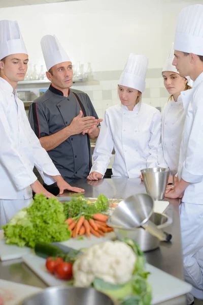 Equipe de chef restaurante ajudando uns aos outros — Fotografia de Stock