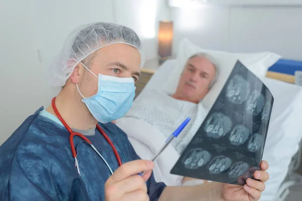 Le médecin vérifie le film à rayons X avec le patient — Photo