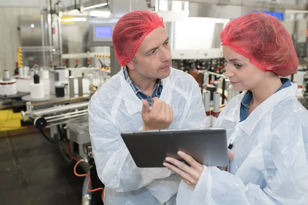 Professionals in safety uniform at work in high tech environment — Stock Photo, Image