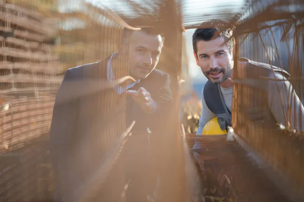 Manager e lavoratore discutendo di materiale di recinzione — Foto Stock