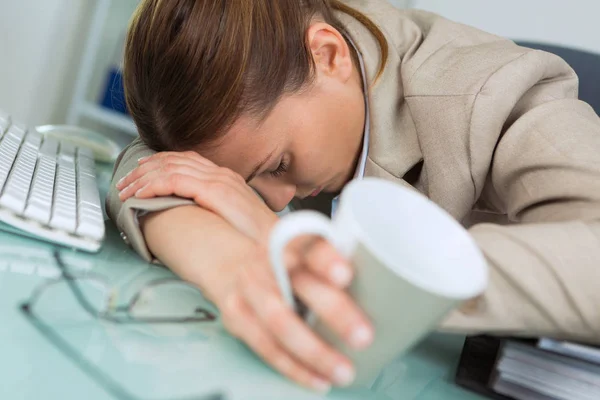 Uitgeput vrouw slapen in kantoor na de dag van hard werken — Stockfoto