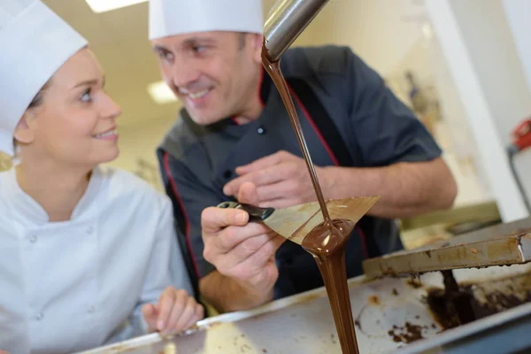 요리사 및 보조 빵집에 초콜릿 녹는 미소 — 스톡 사진