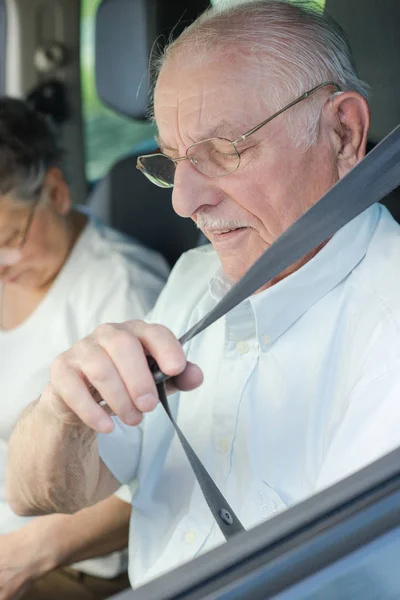 Senior man fastening seat belt before driving car — Stock Photo, Image