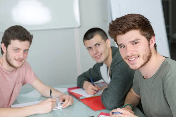 Grupo de estudantes felizes estudando juntos em sala de aula — Fotografia de Stock