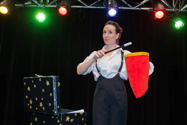 Magicien femme montrant son tour avec baguette magique — Photo