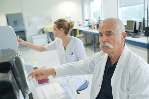 Scienziato senior che guarda lo scivolo al laboratorio — Foto Stock