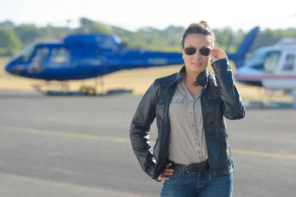 Bonita mujer piloto posando con helicóptero en el fondo —  Fotos de Stock