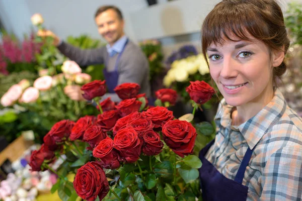 Vrouwelijke en mannelijke bloemist in het werken in de bloemenwinkel — Stockfoto