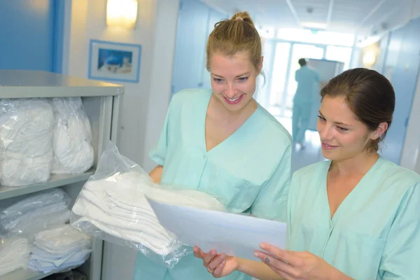 2 肖像护士在医院的检查洗衣单。 — 图库照片