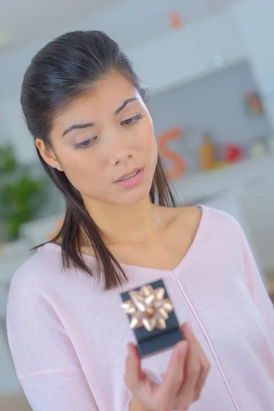 Hermosa eurasiática mujer mirando enagement anillo y dudando — Foto de Stock