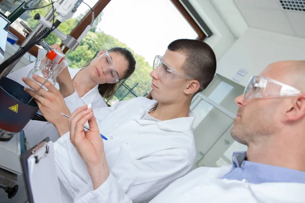 Young phd student scientist looking through a microscope — Stock Photo, Image