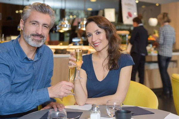 Glada unga par firar födelsedag wih champagne på restaurangen — Stockfoto