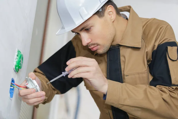 Manos de electricista con destornillador Instalación de enchufe de pared — Foto de Stock