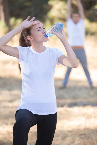 ジョギングの後若い女性は水を飲む — ストック写真