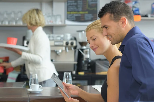 Glimlachend gelukkige paar met tablet pc-computer in het restaurant — Stockfoto