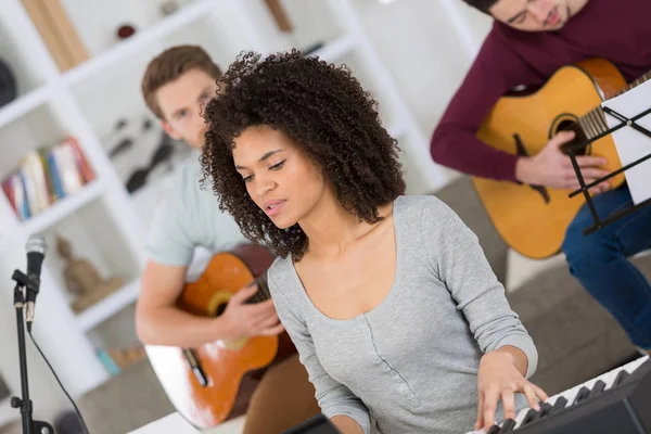 Multiraciale muziekband repeteren in de woonkamer — Stockfoto