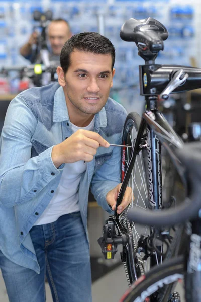 Hombre trabajando en taller de bicicleta — Foto de Stock