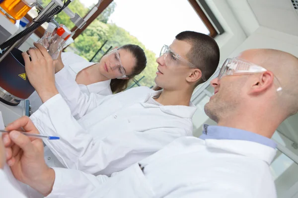 De groep van jonge studenten in heldere chemie lab — Stockfoto