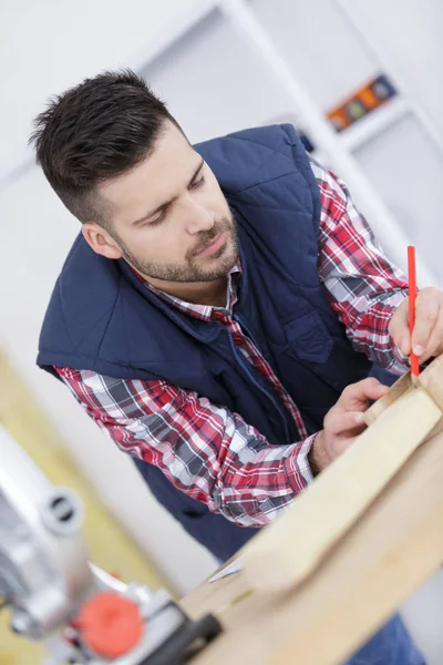 Carpintero trabajando y dibujando sobre madera — Foto de Stock