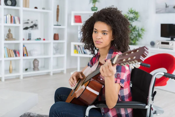 Trendy meisje met gitaar op de rolstoel — Stockfoto