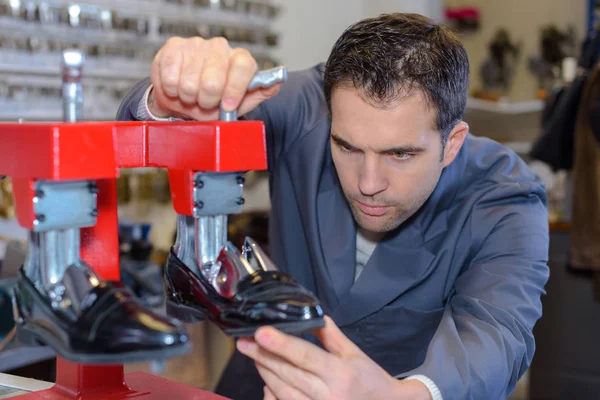 De schoenmaker reparaties een schoen — Stockfoto