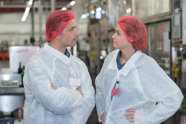 Biólogo equipe falando e vestindo cabeleireiro na fábrica — Fotografia de Stock