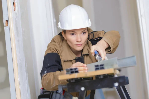 Constructor femenino utilizando una máquina de corte de sierra de mesa electrónica — Foto de Stock