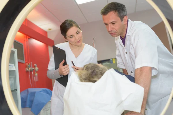 Mitte erwachsenes medizinisches Personal bereitet Patienten auf Tomographie vor — Stockfoto